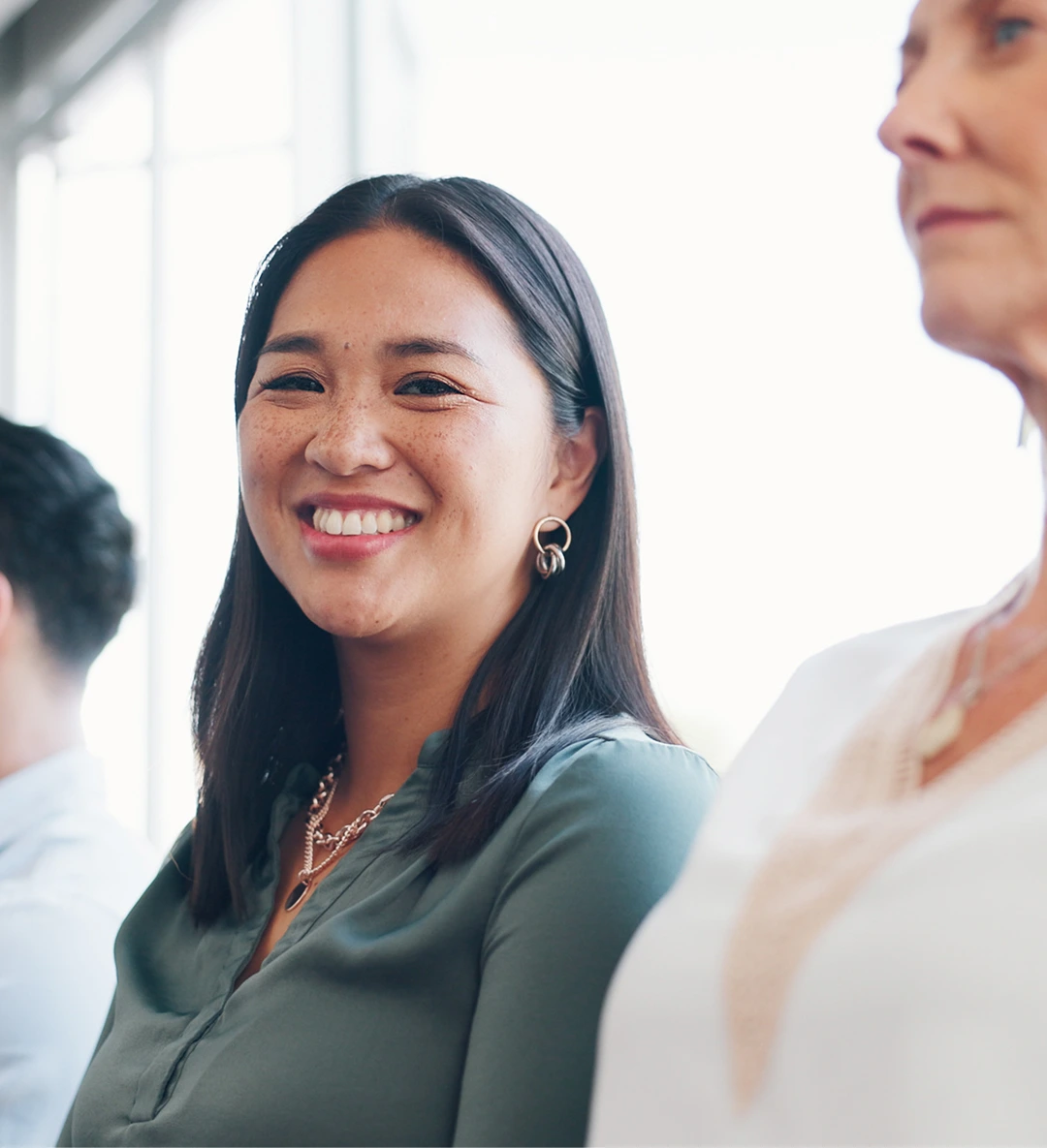 Asian woman is participating in an office event, and looks at the camera and smiles