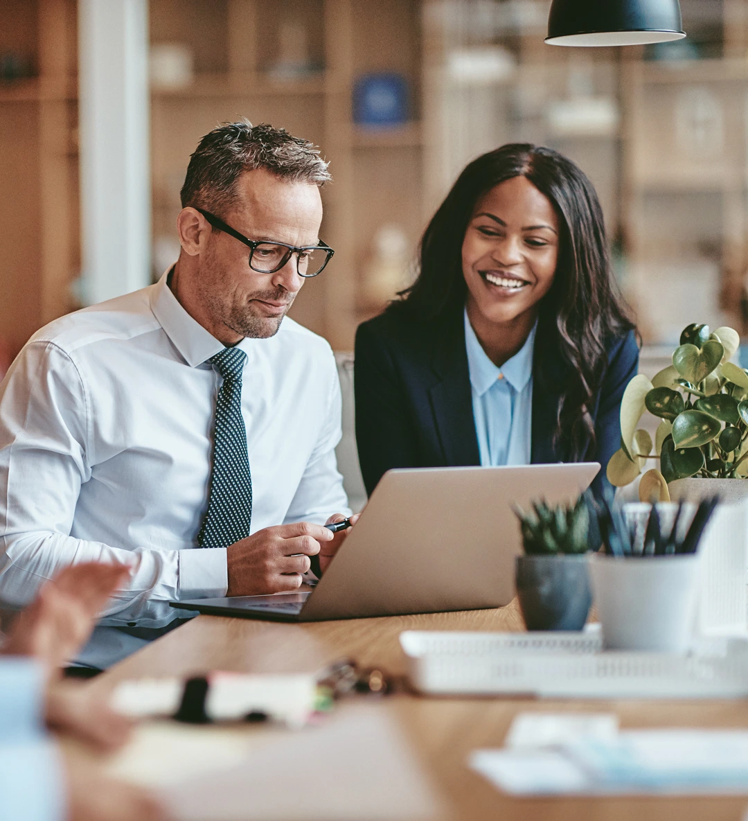 A man and a woman joyously discuss work in the office.
